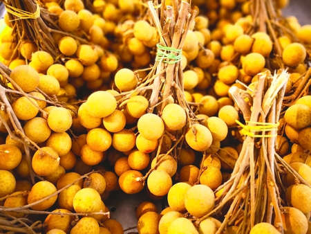Fruit concept. Many bunches of longan are in a rattan basket for sale in supermarket. Selective focus and copy space.の写真素材