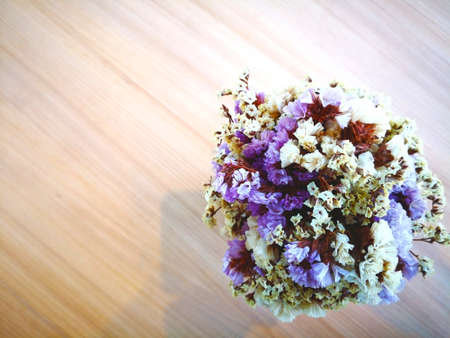 Love concept. Dry purple flowers and white flowers are arranged in a vase wrapped in a rope. Located...