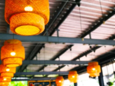 The concept of handmade natural decorations. Handmade bamboo lantern, decorated for light on the ceiling. Blurred background and copy space.の写真素材
