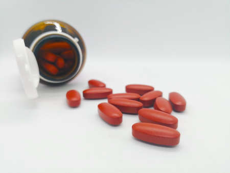 Medication and healthcare concept. Many oval brown tablets of multivitamin, that are also used to...