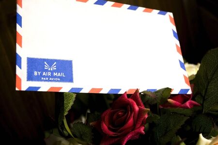 Air mail envelop put on roses. の写真素材