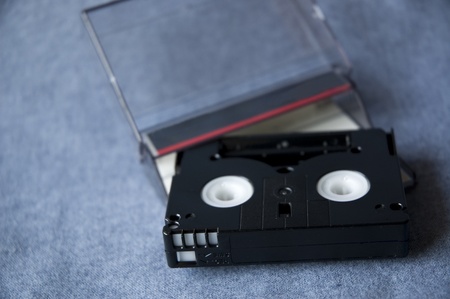 mini DV cassette tape and clear tape box on blue background.の写真素材