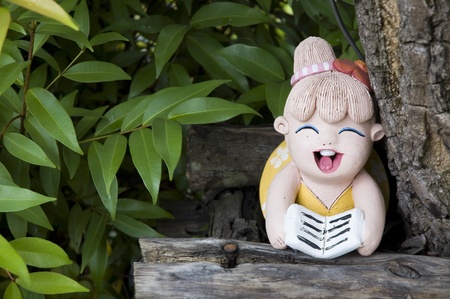 painted clay doll girl reading in gardenの写真素材