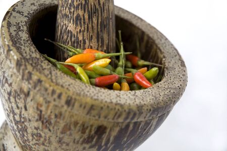 close up chili in mortar on white backgroundの写真素材