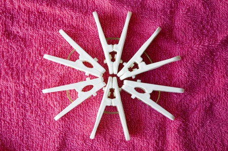 white plastic clothes pins put on pink towelの写真素材