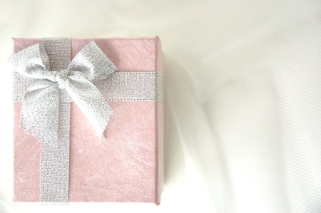 top view of pink gift box with silver ribbon on whiteの写真素材