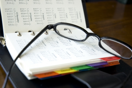 eyeglasses put on calendar page of personal organizerの写真素材