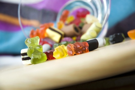 close up green gummy with variety candies on tableの写真素材