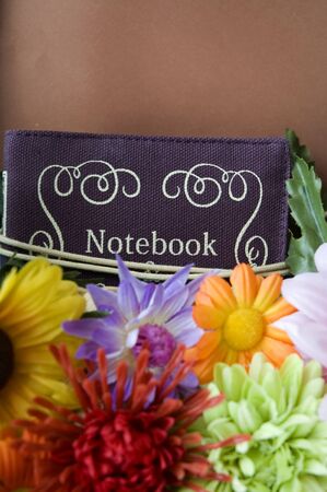 notebook put on artificial flowersの写真素材