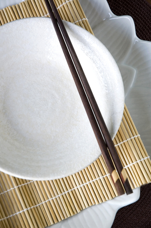 white dish with chopstick on bamboo matの写真素材