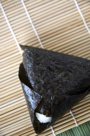 close up japanese rice ball on bamboo matの写真素材