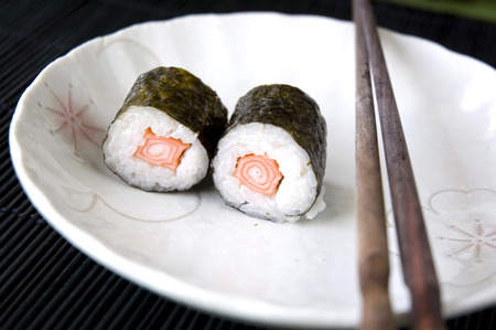 sushi on white plate with chopsticksの写真素材
