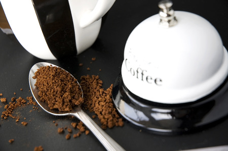 close up coffee in spoon put beside coffee cup and ring bellの写真素材