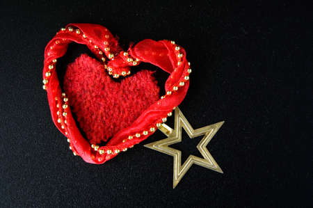 red heart decorations with golden star on black backgroundの写真素材