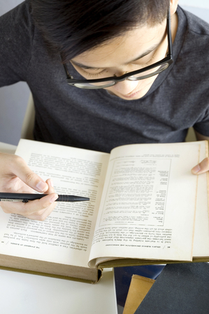 young asian chinese busy reading text bookの写真素材