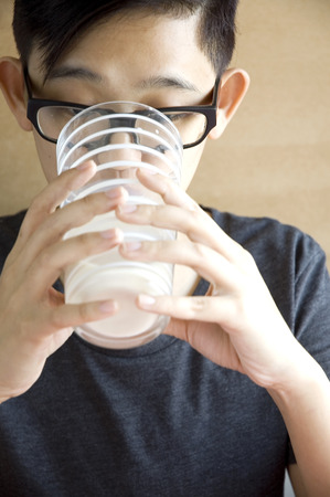 young asian drinking milk from glassの写真素材