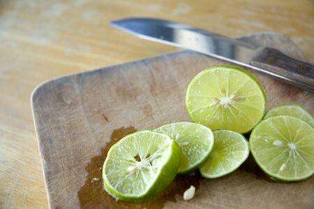 close up pieces of lime on wooden cutting board