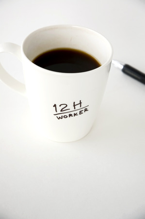 12h worker black coffee cup on white backgroundの写真素材