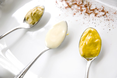 close up mustard on spoon with condiment backgroundの写真素材
