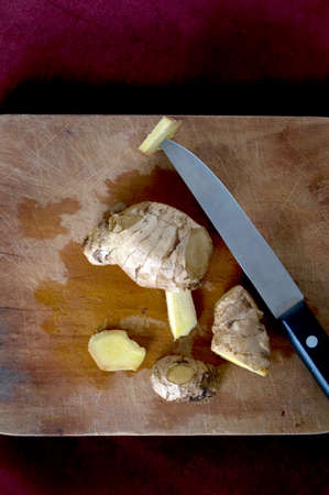 sliced fresh ginger root on wooden cutting boardの写真素材