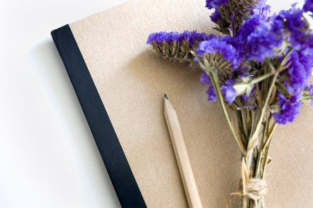 natural color book and pencil with purple flowersの写真素材