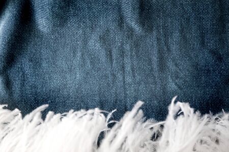 dark blue shade fabric background with white soft feather on foreground