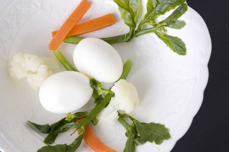 boiled egg and veggie on white plateの写真素材