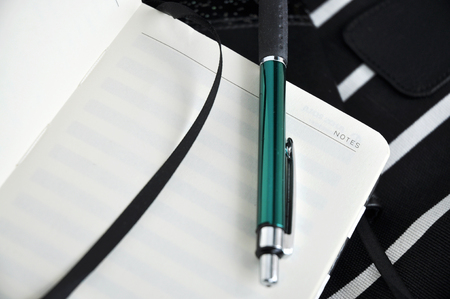 close up green pen put on blank notebookの写真素材