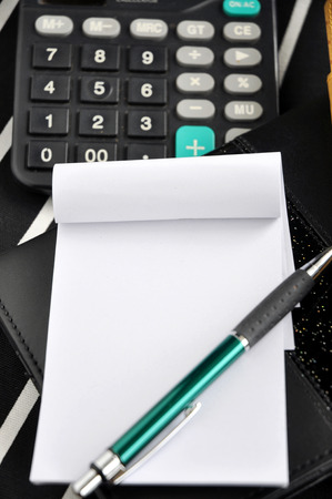 blank white paper and pen with calculator backgroundの写真素材