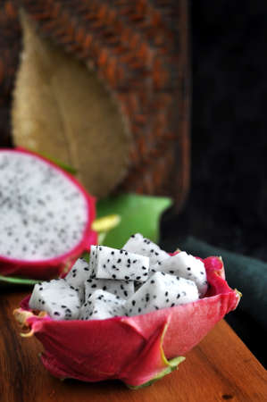fresh dragon fruit with golden plate and wooden texture on backgroundの写真素材