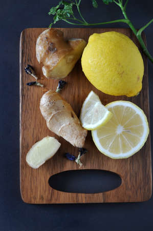 Top view of fresh lemon and ginger on wooden boardの写真素材