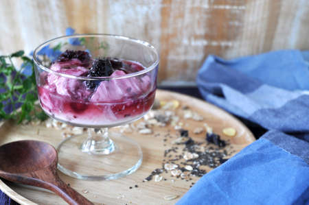 Glass of blueberry yogurt on wooden plate