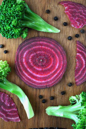 Above pieces of beetroot and broccoli on wooden boardの写真素材