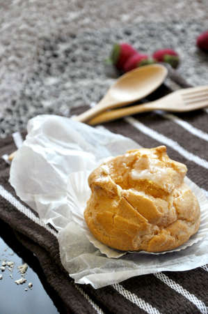 Close up Choux cream with wooden fork and spoon on background