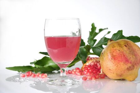 Fresh pink pomegranate juice with pomegranate on white backgroundの写真素材