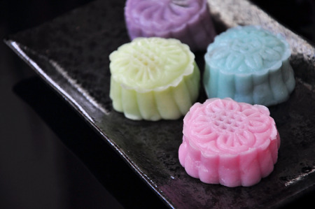 Close up colorful snow skin mooncake on black plate put on black background
