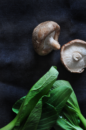 Top view of mushroom and fresh vegetable on black fabric backgroundの写真素材