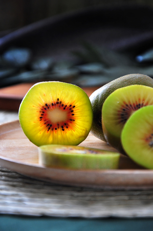 Close up details of red kiwifruit on wooden plateの写真素材