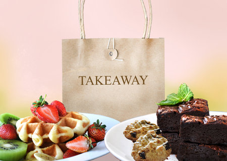 Takeaway paper bag with bakery dish on pastel color backgroundの写真素材