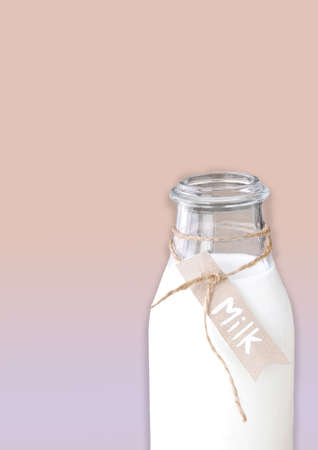 Close up milk bottle with paper tag on pastel color backgroundの写真素材
