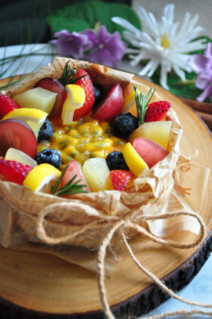 Close up summer fruits topping on new york cheesecake serve on wooden board decorated with flowers on backgroundの写真素材
