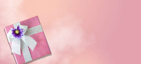Pink gift box on pink background with copy space in banner size imageの写真素材