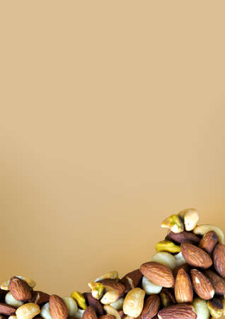 Pile of healthy mixed nuts on brown background with copy space