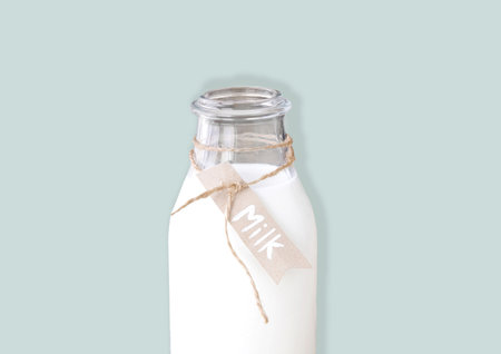 Milk glass bottle on blue background with space for textの写真素材