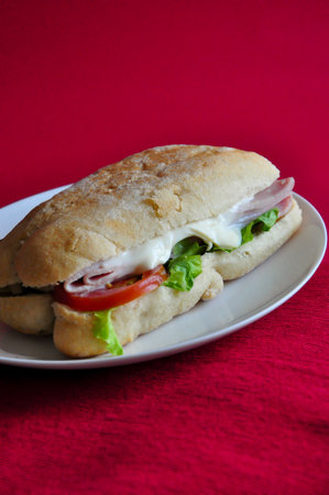 Close up ham cheese sandwich on white dish put on red background with copyspaceの写真素材