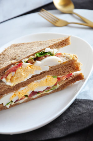 Close up fresh egg homemade egg sandwich on white plateの写真素材