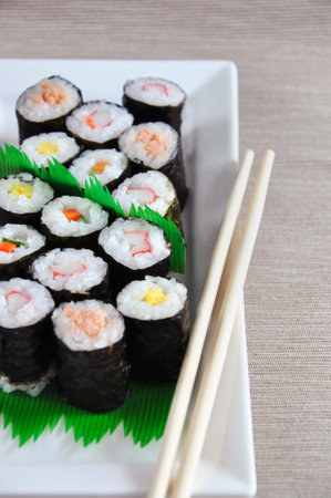 Fresh sushi rolls serve on white plate with chopstickの写真素材