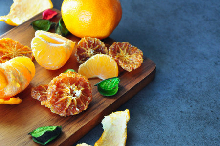 Sliced dried Mandarin orange with fresh orange on wooden boardの写真素材