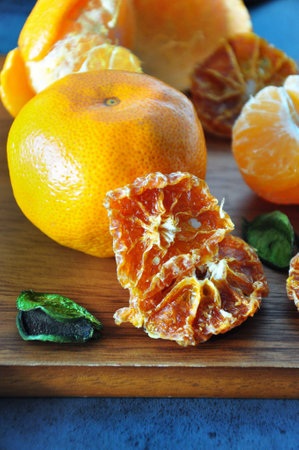 Close up sliced dried Mandarin orange with fresh orange on wooden boardの写真素材