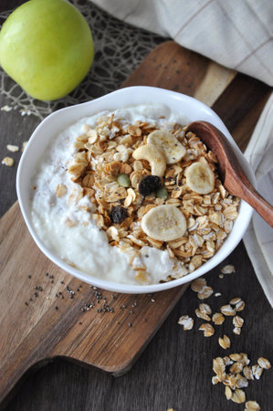 Close up yogurt bowl topping with granola and dried fruit put on wooden board backgroundの写真素材
